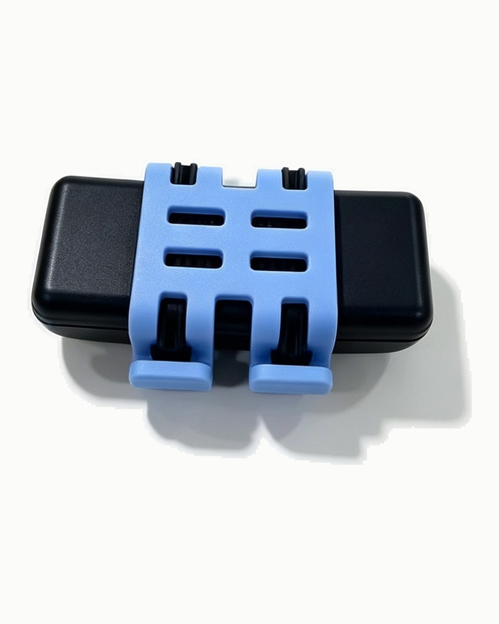 Le support en silicone clipsé sur le boîtier : les quatre fentes où passe le collier de l’angle.